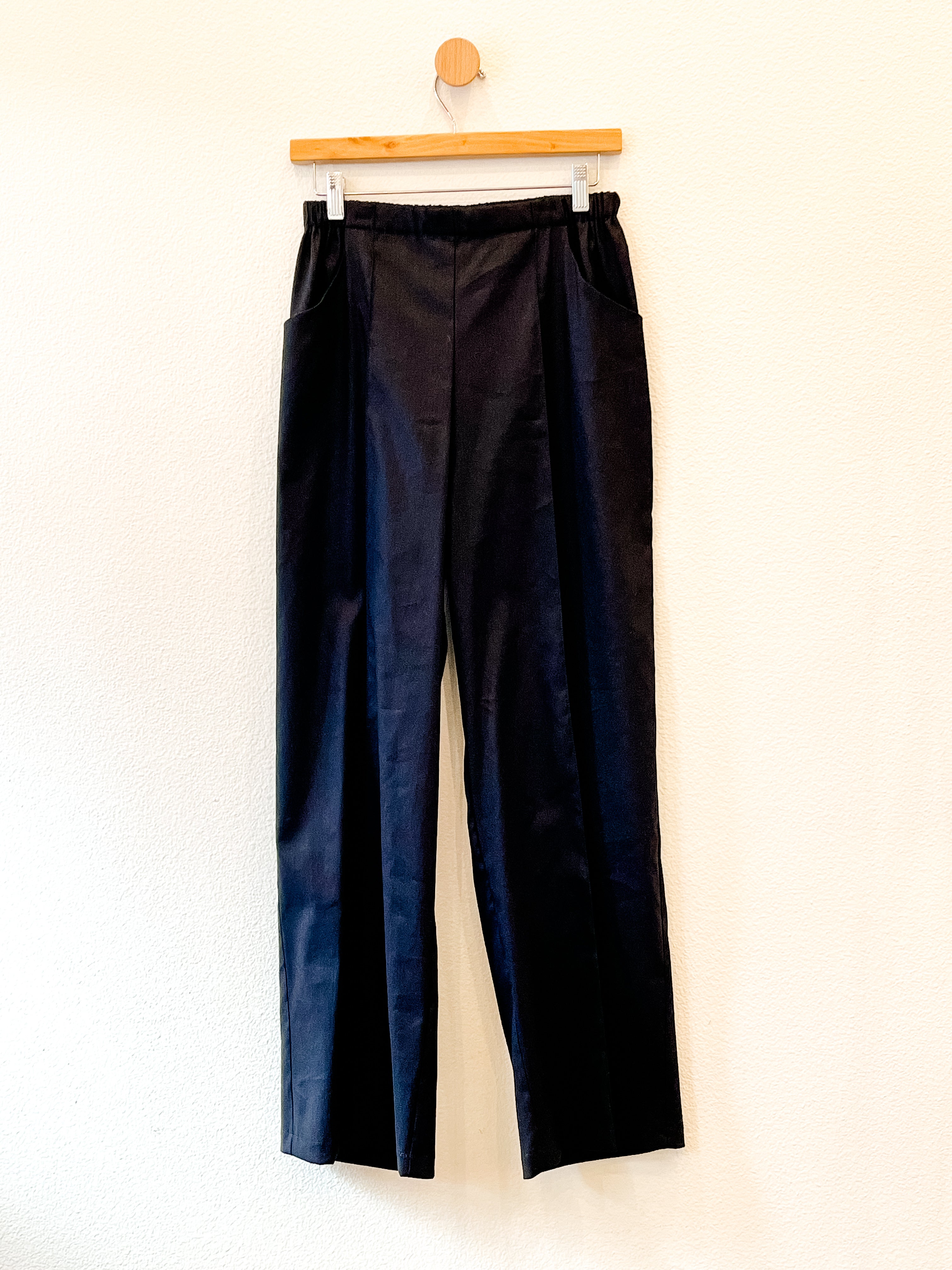 A pair of black pants on a hangar.