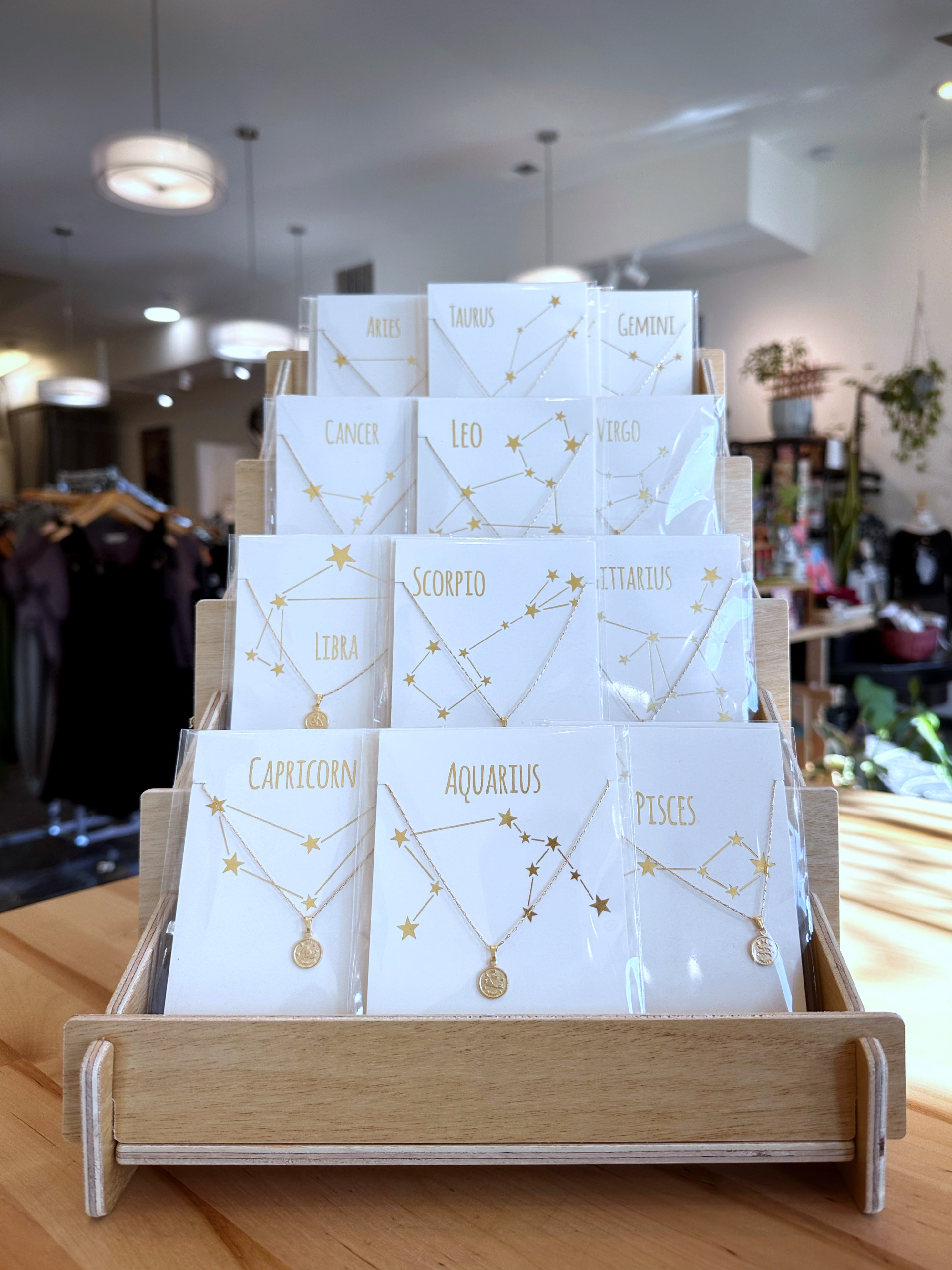 A display of packaged zodiac necklaces