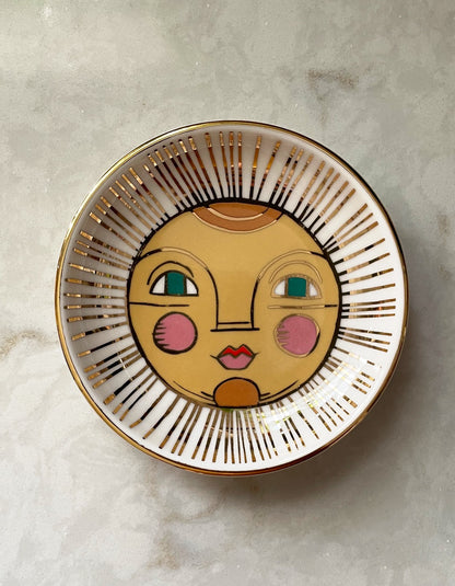 a trinket dish with a sun themed face